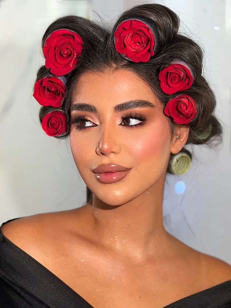 مكياج غلام مع رولرات مزيّنة بورود حمراء